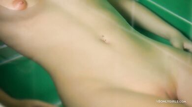 Teen plays in the bathtub with shower head