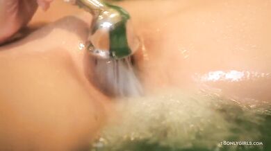 Teen plays in the bathtub with shower head