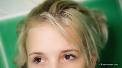 Teen plays in the bathtub with shower head