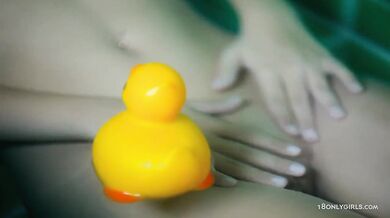 Teen plays in the bathtub with shower head